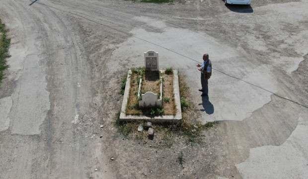 Yol ortasında kalan mezar görenleri şaşırtıyor